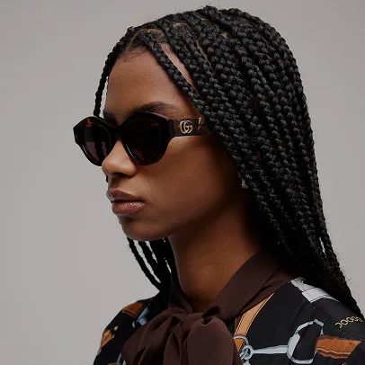 Femme élégante coiffée de tresses portant des lunettes solaires